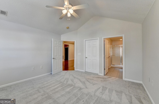 unfurnished bedroom with vaulted ceiling, baseboards, visible vents, and light carpet
