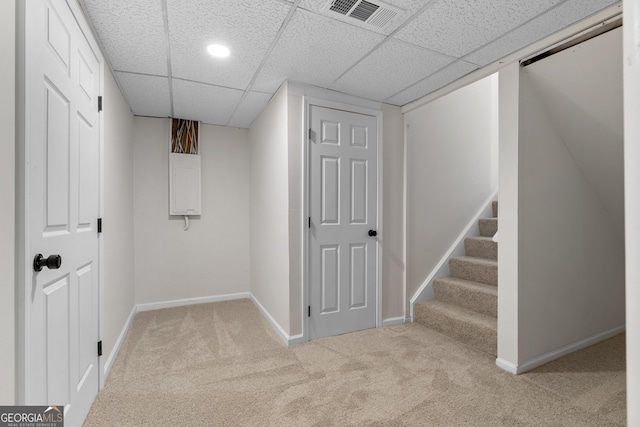 finished below grade area with visible vents, baseboards, carpet flooring, and stairway
