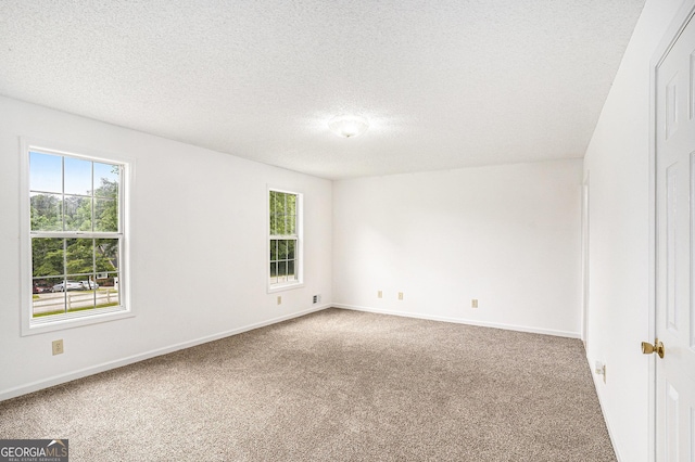 carpeted spare room with baseboards, a textured ceiling, and a healthy amount of sunlight