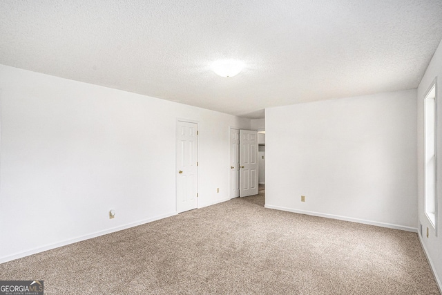 unfurnished bedroom with baseboards, carpet, and a textured ceiling