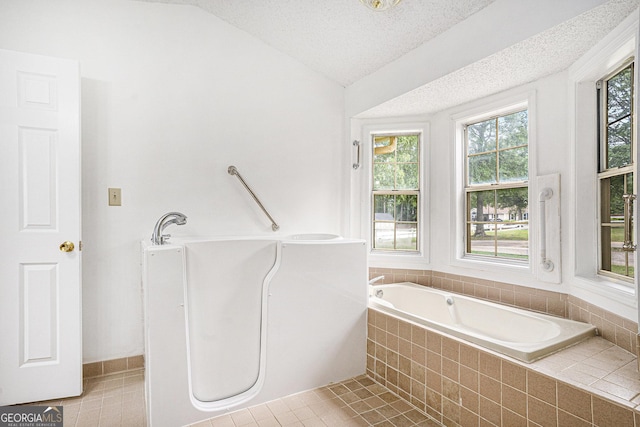 bathroom featuring a bath, lofted ceiling, and tile patterned floors