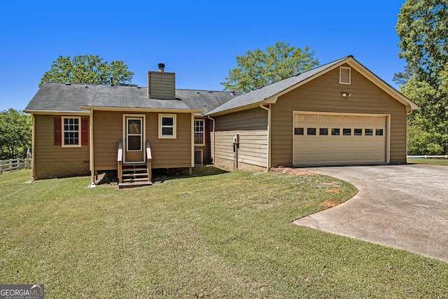 back of property with driveway, a chimney, a lawn, fence, and entry steps