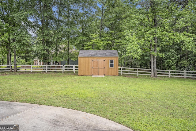 view of yard with a storage shed, an outbuilding, and a fenced backyard