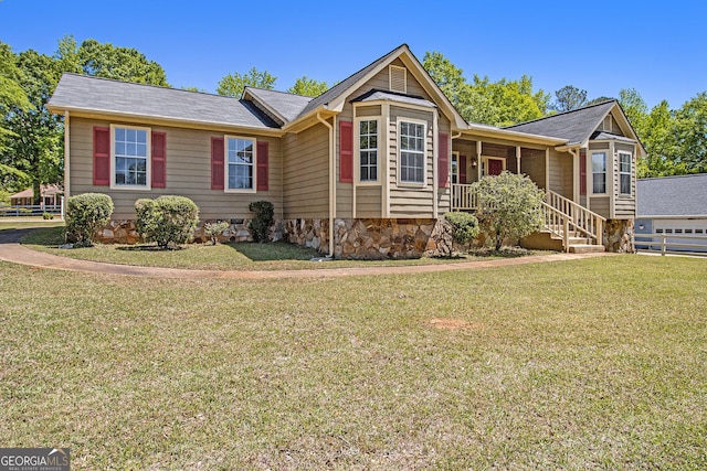 ranch-style home featuring covered porch and a front yard