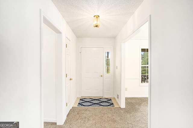 entryway featuring carpet floors, a textured ceiling, and baseboards
