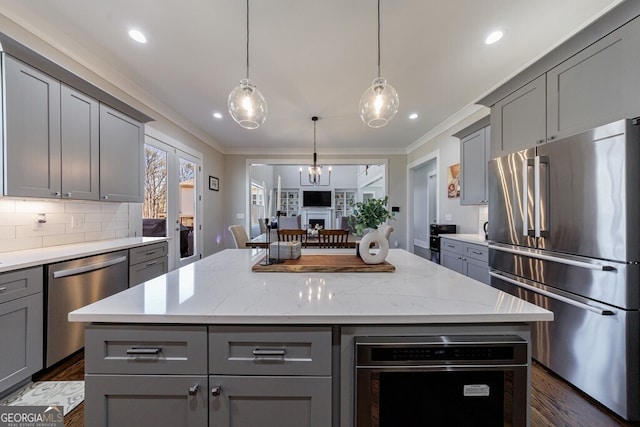 kitchen with ornamental molding, gray cabinets, and appliances with stainless steel finishes