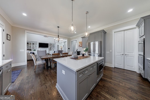 kitchen featuring gray cabinets, appliances with stainless steel finishes, and ornamental molding