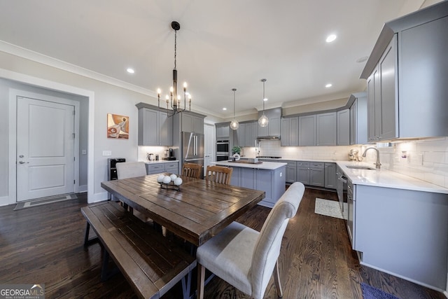 dining area with crown molding, dark wood-style flooring, an inviting chandelier, and recessed lighting