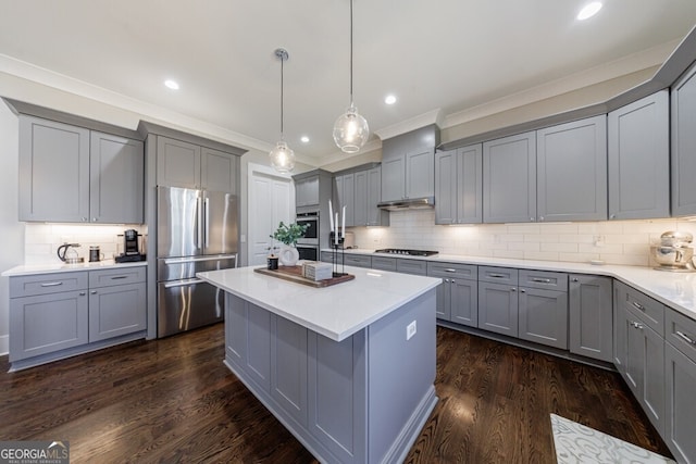 kitchen featuring dark wood-type flooring, tasteful backsplash, ornamental molding, appliances with stainless steel finishes, and gray cabinetry