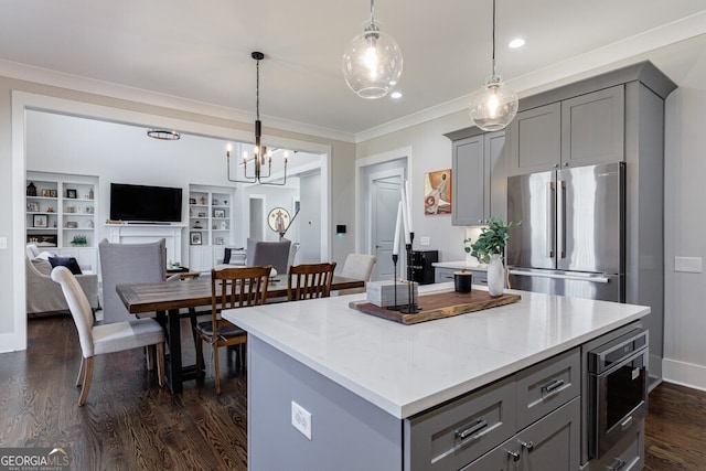 kitchen with pendant lighting, a kitchen island, stainless steel appliances, gray cabinetry, and dark wood-style floors