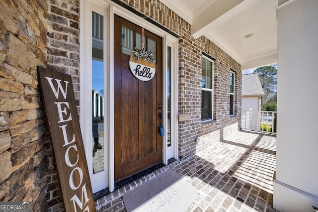 entrance to property with covered porch and brick siding