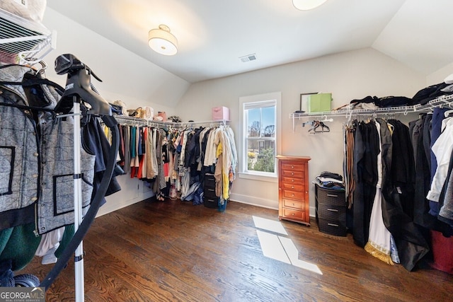 walk in closet featuring wood finished floors, visible vents, and lofted ceiling