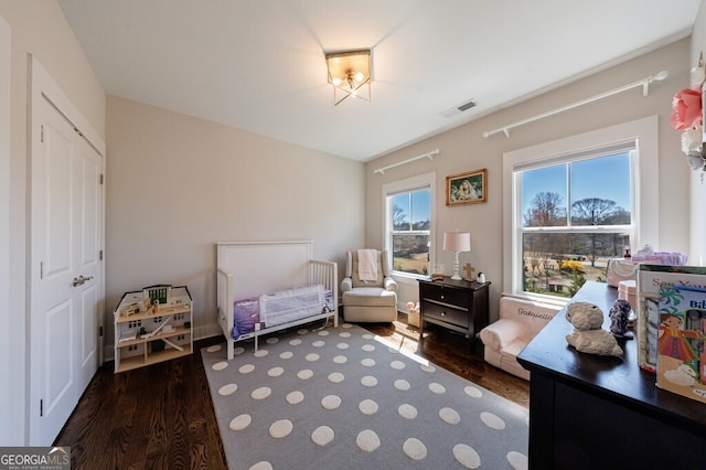 bedroom featuring visible vents and wood finished floors