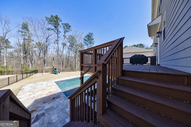 exterior space with a fenced in pool, a patio, stairs, fence, and a playground