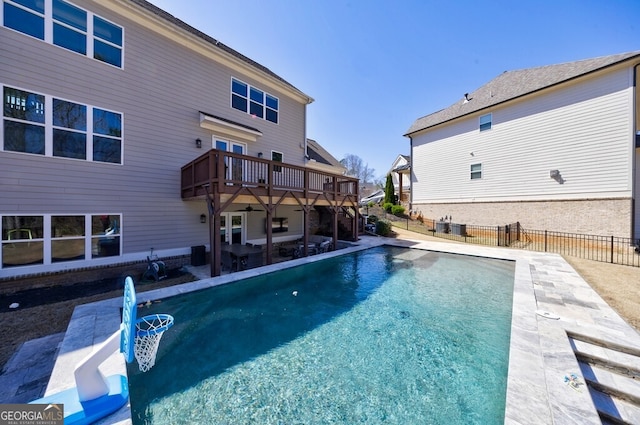 view of pool with fence, a wooden deck, a fenced in pool, and a patio