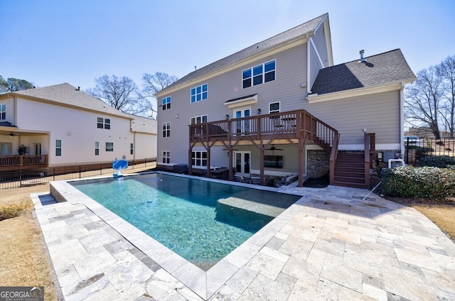 back of property featuring a wooden deck, stairway, a patio, roof with shingles, and fence