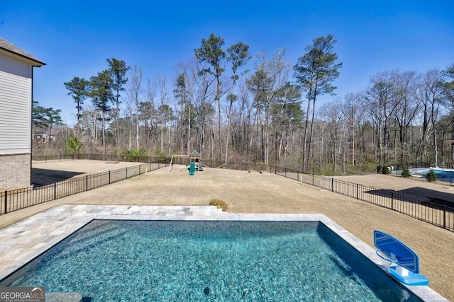 view of swimming pool with playground community, a fenced backyard, a fenced in pool, and a patio area