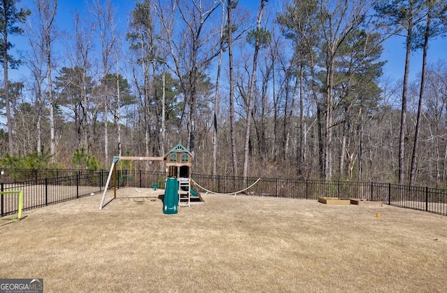 communal playground with a view of trees, fence, and a lawn