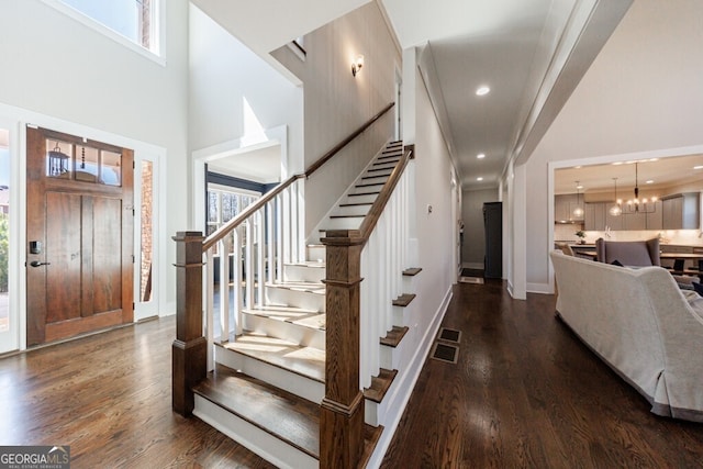 foyer entrance with stairway, a high ceiling, and a healthy amount of sunlight