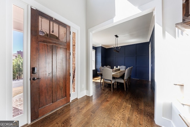 foyer entrance with a chandelier and dark wood finished floors