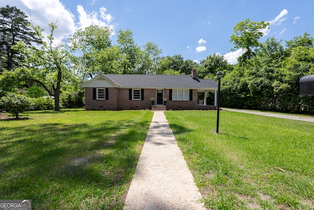 single story home featuring crawl space, a chimney, brick siding, a front lawn, and driveway