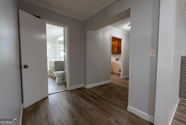 hallway featuring crown molding, wood finished floors, and baseboards