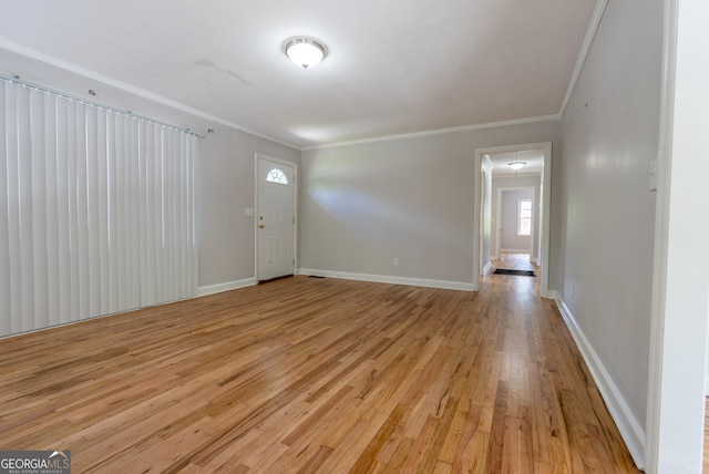 foyer featuring crown molding, light wood finished floors, and baseboards
