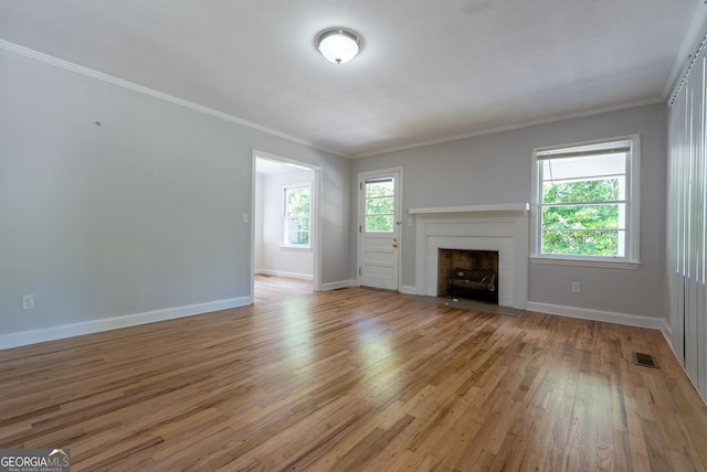 unfurnished living room with light wood-style floors, baseboards, a fireplace, and ornamental molding