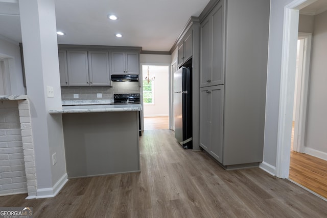 kitchen with freestanding refrigerator, gray cabinets, range hood, black range with electric stovetop, and wood finished floors