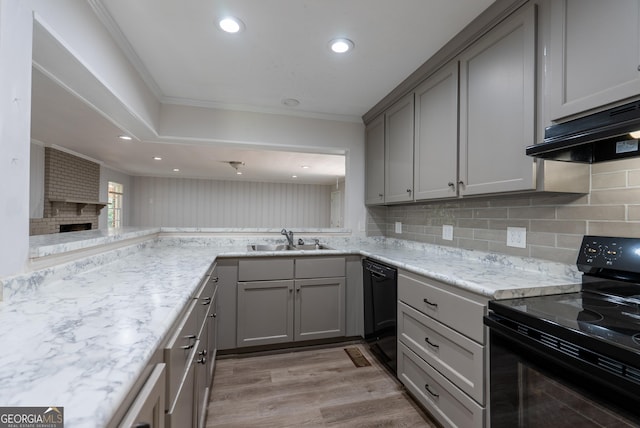kitchen with black appliances, a sink, gray cabinets, under cabinet range hood, and crown molding