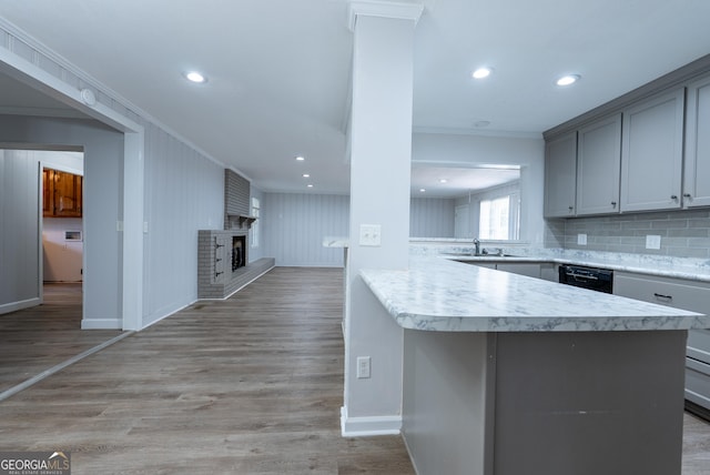 kitchen featuring ornamental molding, gray cabinetry, light countertops, dishwasher, and baseboards