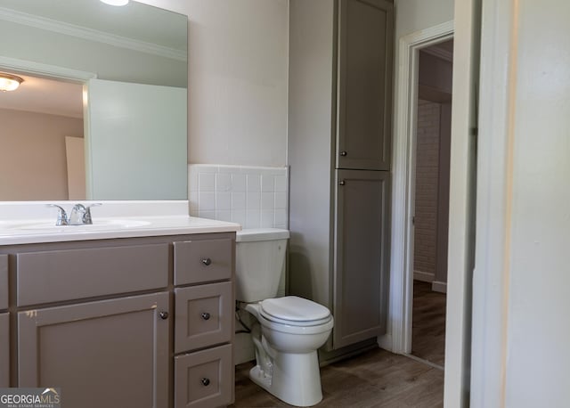 bathroom featuring ornamental molding, wood finished floors, toilet, and vanity