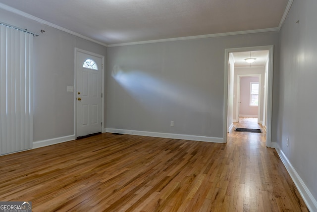 entryway with hardwood / wood-style floors, healthy amount of natural light, crown molding, and baseboards