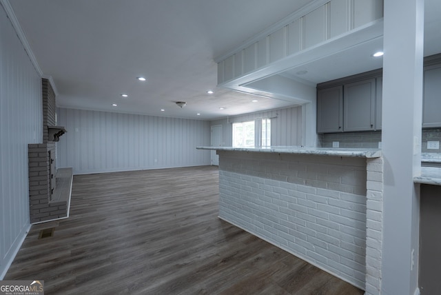 unfurnished living room featuring a fireplace, dark wood finished floors, crown molding, recessed lighting, and baseboards