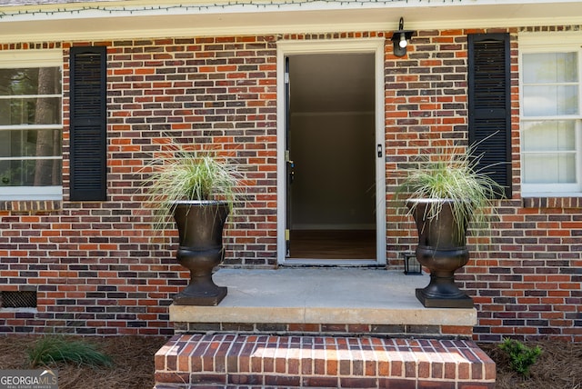 view of exterior entry with brick siding