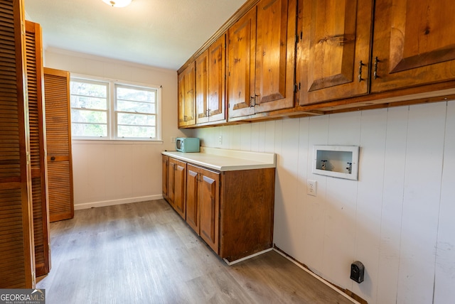 laundry area featuring cabinet space, light wood-style floors, and washer hookup