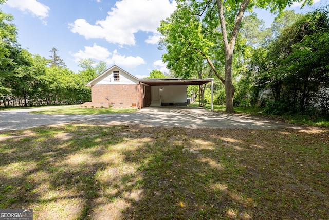 view of side of home featuring an attached carport, crawl space, and brick siding