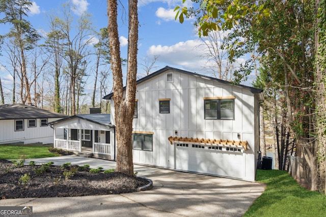 7410 Fields Dr, Cumming, GA 30041 - view of front of property featuring a garage, board and batten siding, driveway, and a porch