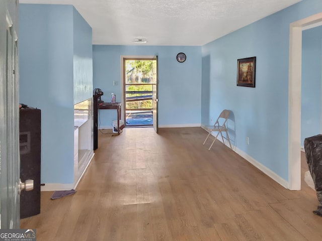 hallway featuring baseboards and wood finished floors