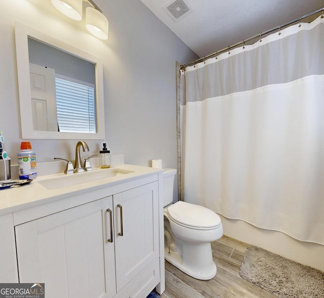 5612 Hickory Dr, Patterson, GA 31557 - bathroom with visible vents, shower / bath combo with shower curtain, toilet, wood finished floors, and vanity