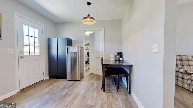 5612 Hickory Dr, Patterson, GA 31557 - kitchen with hanging light fixtures, baseboards, light wood finished floors, and a textured ceiling