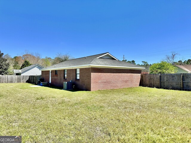 5612 Hickory Dr, Patterson, GA 31557 - view of property exterior with brick siding, a lawn, a fenced backyard, and central AC