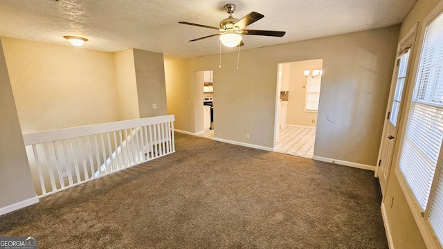 2172 Nancy Way, Loganville, GA 30052 - spare room featuring baseboards, ceiling fan with notable chandelier, a textured ceiling, and carpet