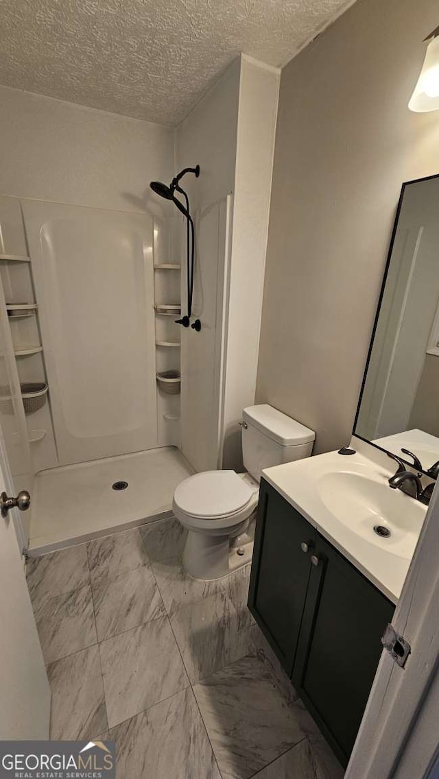 2172 Nancy Way, Loganville, GA 30052 - bathroom featuring toilet, marble finish floor, a textured ceiling, a shower stall, and vanity