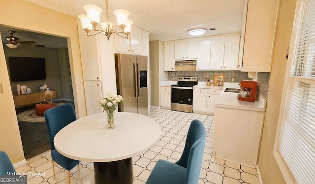 2172 Nancy Way, Loganville, GA 30052 - kitchen featuring under cabinet range hood, white cabinetry, appliances with stainless steel finishes, light countertops, and decorative backsplash