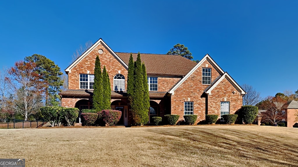 2413 Brynlynn Woods, Conyers, GA 30013 - view of front of house with brick siding, a front yard, and fence