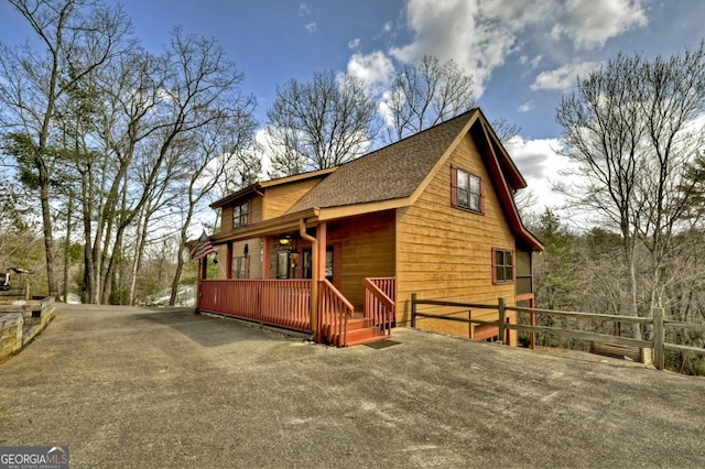 65 Weoka Ct, Ellijay, GA 30540 - view of side of property with fence, a porch, roof with shingles, and driveway
