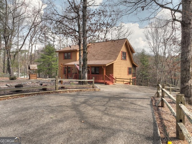 65 Weoka Ct, Ellijay, GA 30540 - view of front of home with covered porch, roof with shingles, fence, and driveway