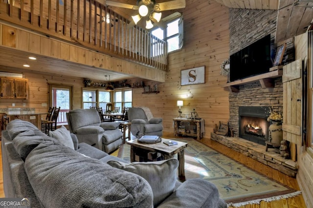 65 Weoka Ct, Ellijay, GA 30540 - living area with a high ceiling, wood finished floors, wooden walls, a stone fireplace, and a ceiling fan