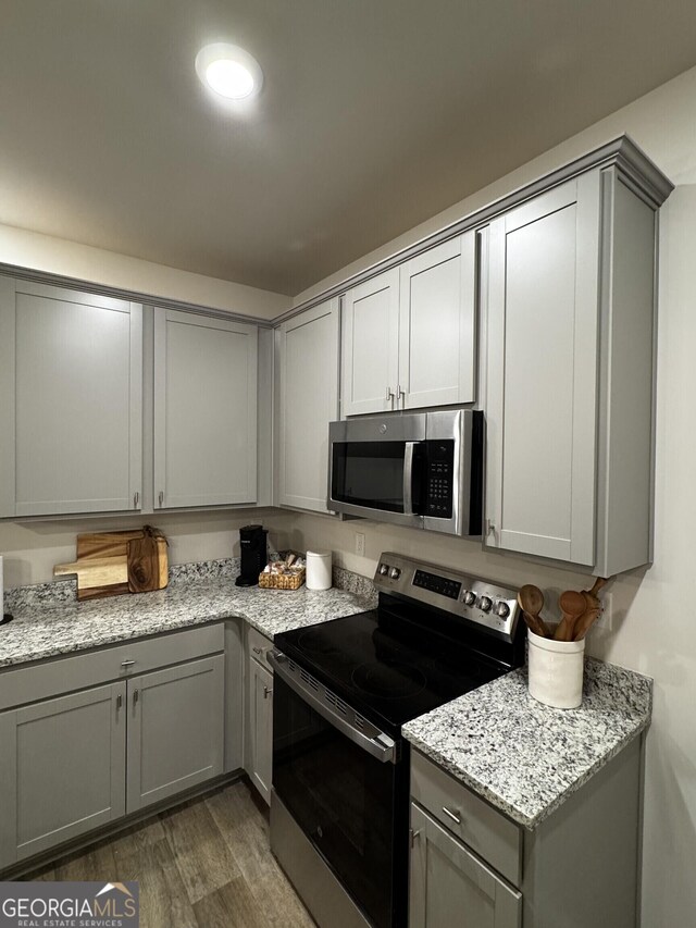 235 Ivey Ter Unit 40, Temple, GA 30179 - kitchen featuring light stone counters, appliances with stainless steel finishes, dark wood-style floors, and gray cabinets